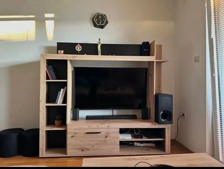 Living room with wooden TV unit and television.