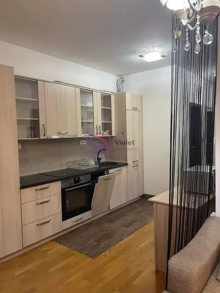 Kuhinja sa drvenim elementima i ugradnim aparatima.