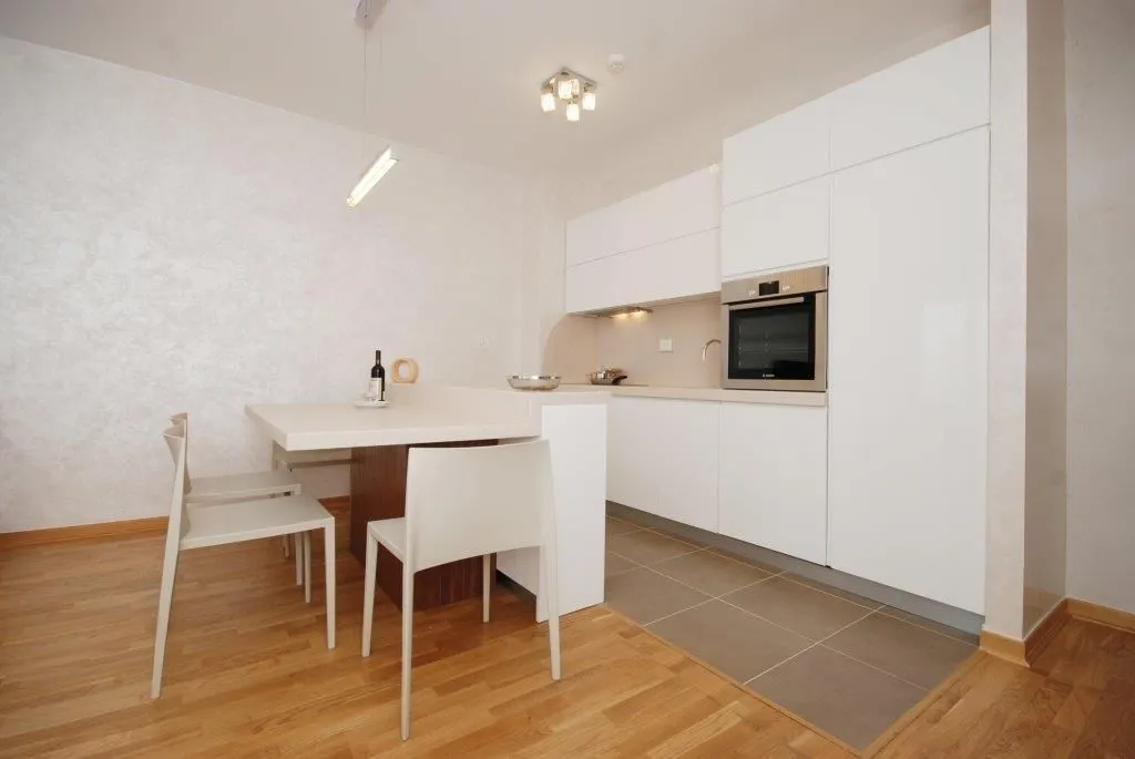 Modern white kitchen with a dining table.