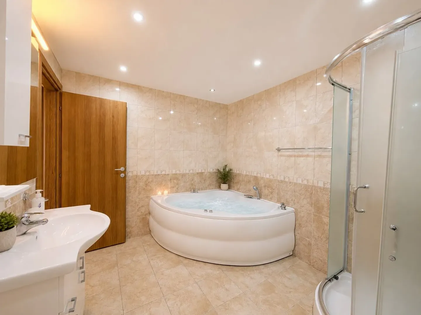 Spacious bathroom with a corner bathtub, shower cabin, and washbasin.