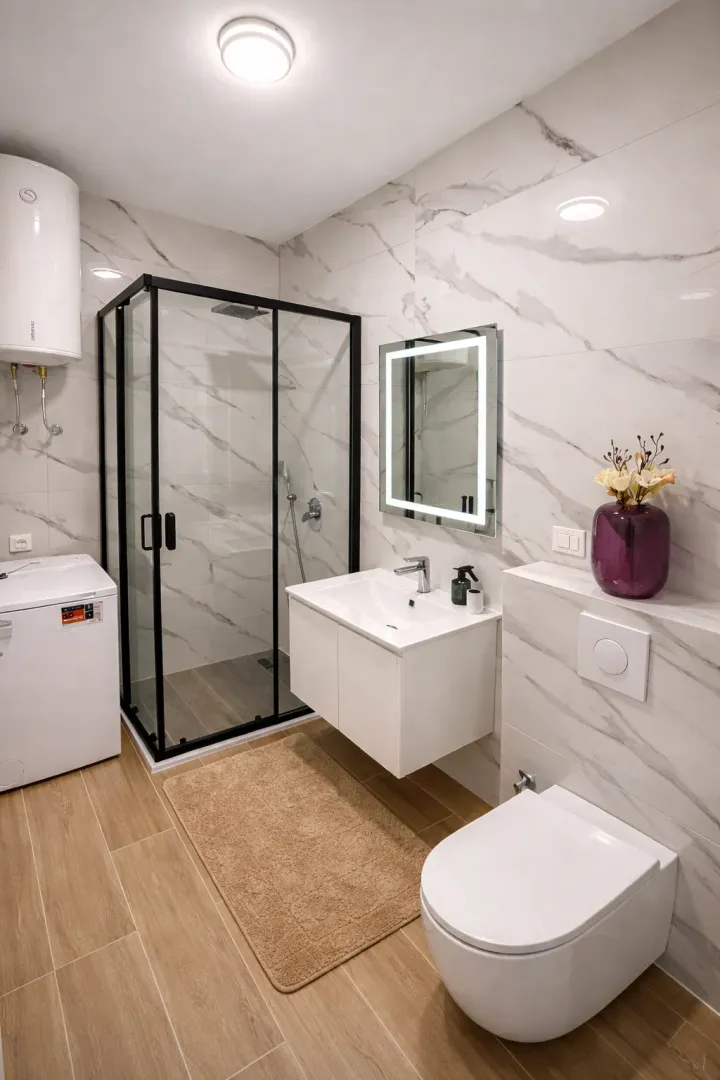 Moderne opremljeno kupatilo sa tuš kabinom, umivaonikom i WC šoljom.