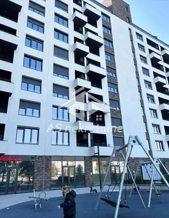 View of the exterior of the residential building with a playground in the yard.