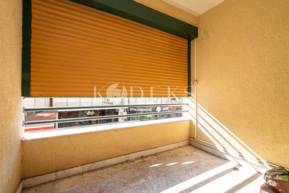 Covered balcony with a lowered roller shutter and street view.