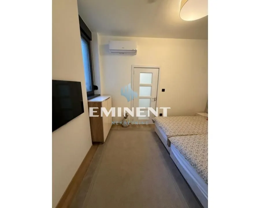 Bedroom with a bed, television and air conditioning.