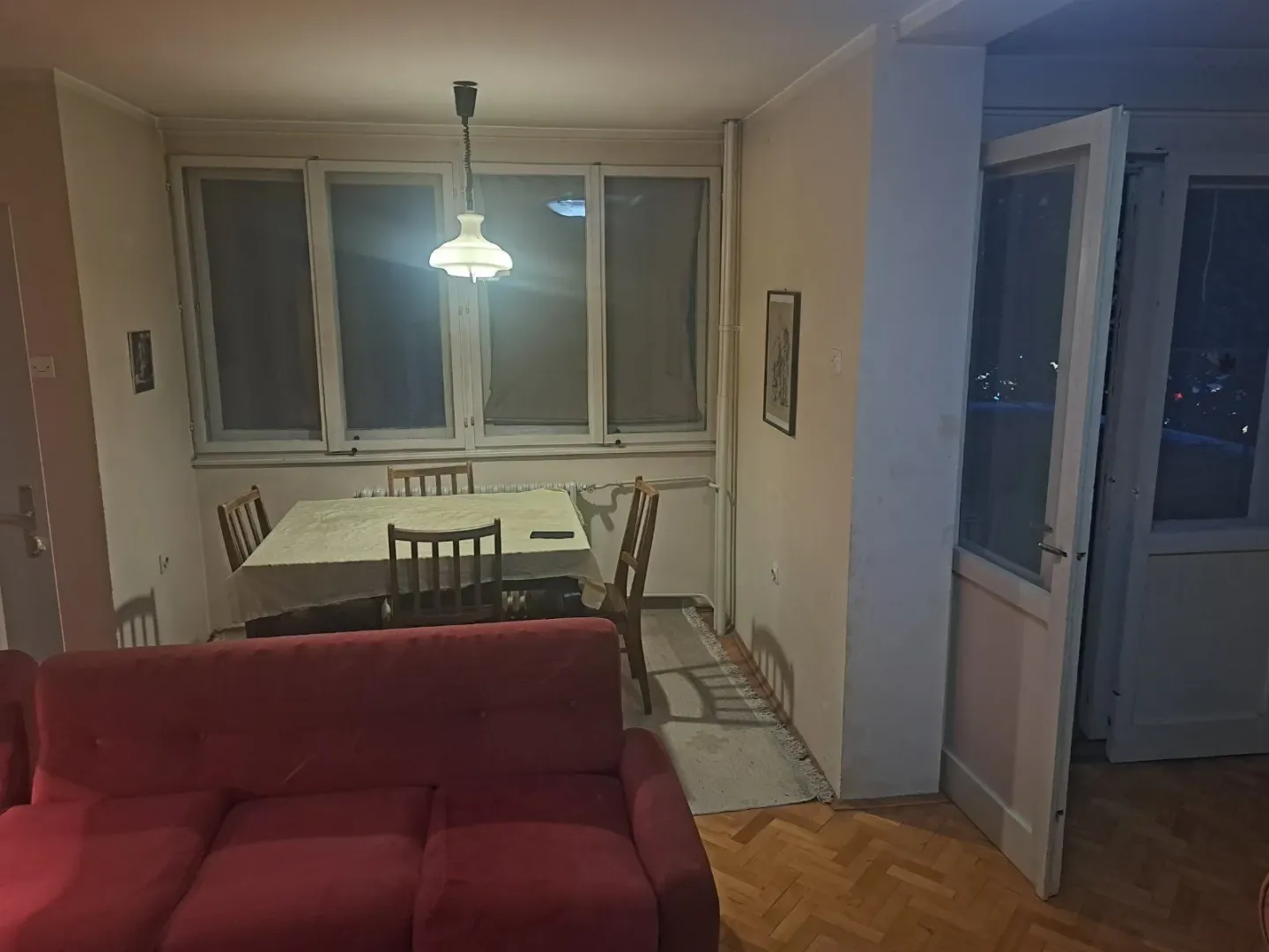 Living room with a sofa and a dining table near the window.