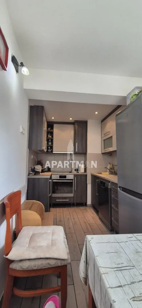 Smaller kitchen with dark cabinets and a dining table in the foreground.