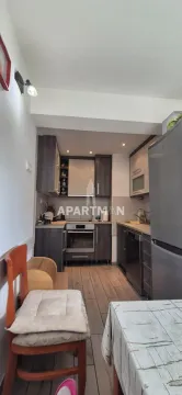 Smaller kitchen with dark cabinets and a dining table in the foreground. - image 18