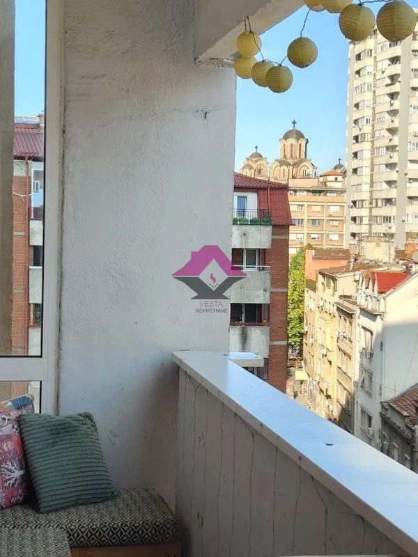 View from the balcony overlooking city buildings and a church.