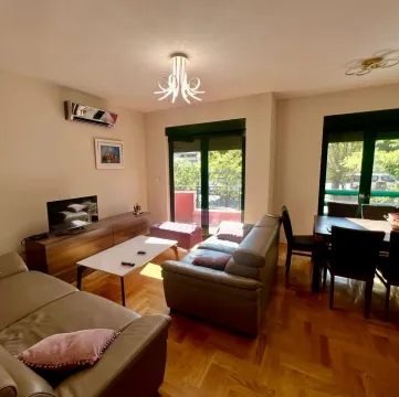 Spacious living room with a sofa set, TV, and dining area. - image 3