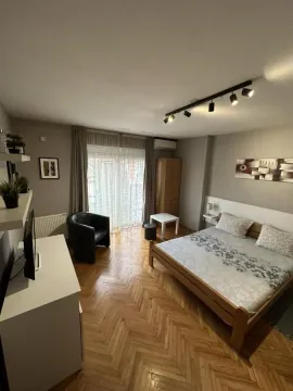 Nameštena spavaća soba sa bračnim krevetom, foteljom i parketom na podu. - image 4