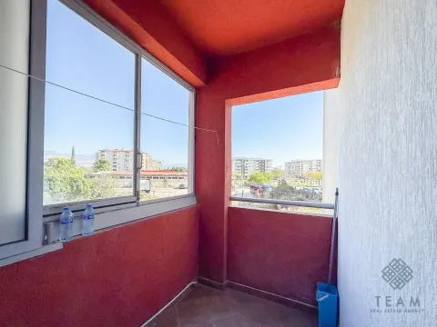 Covered balcony with a view of surrounding buildings and the city. - image 2