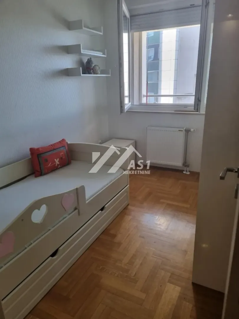 Dečja soba sa krevetom i prozorom.