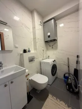 Savremeno opremljeno kupatilo sa umivaonikom, wc šoljom, veš mašinom i bojlerom. - image 8