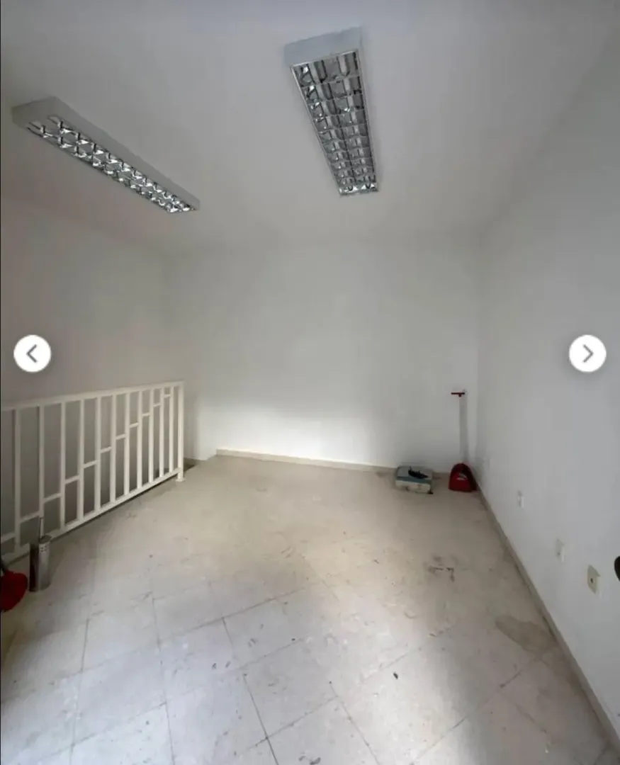 Empty unfurnished room with white walls and tiled flooring.