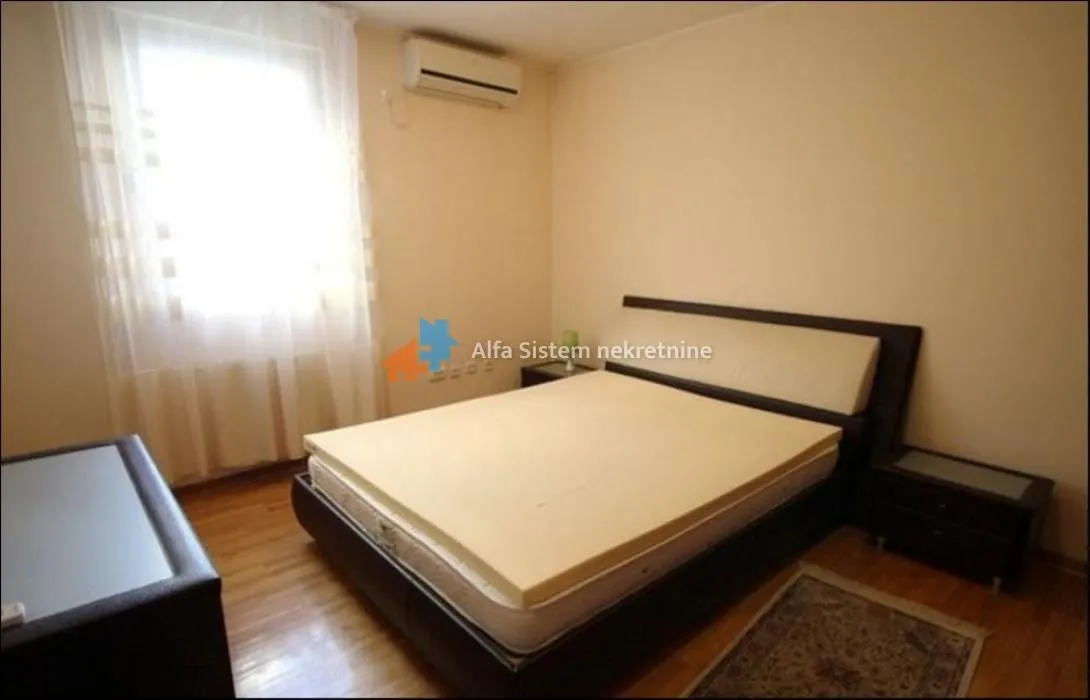 Furnished bedroom with a double bed and a window.