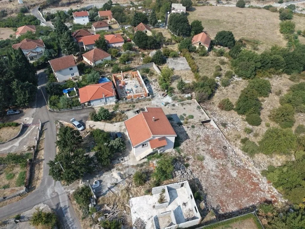 Pogled iz vazduha na kuću sa dvorištem i okolno naselje.