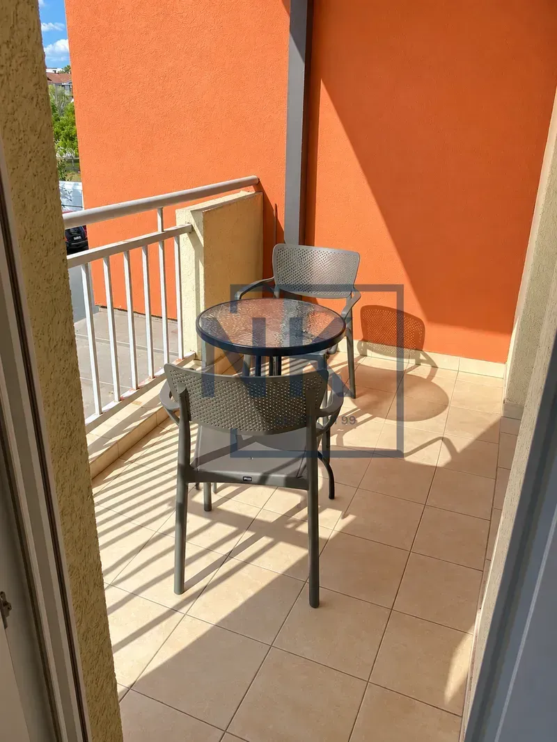 Manji namješteni balkon sa stolom i dvije stolice.