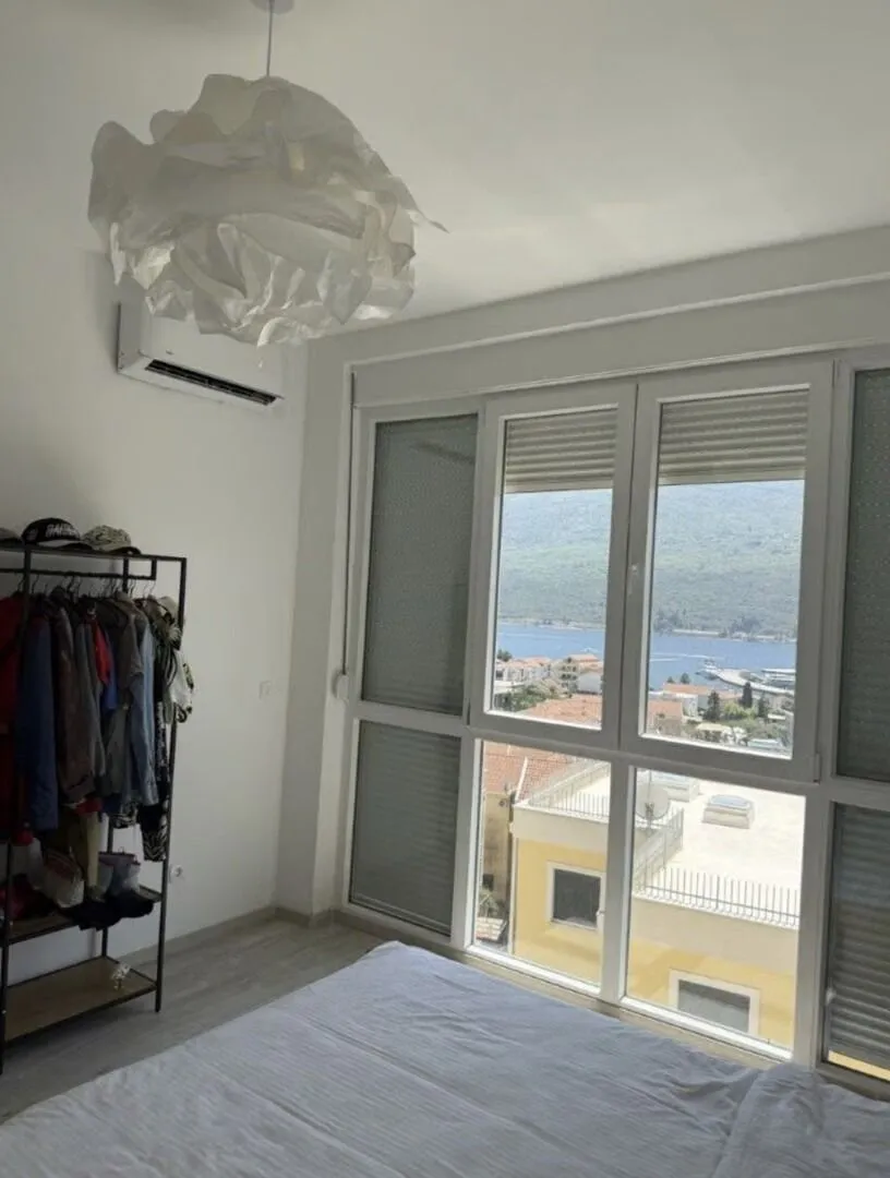 Spavaća soba sa krevetom, garderoberom i pogledom na more.