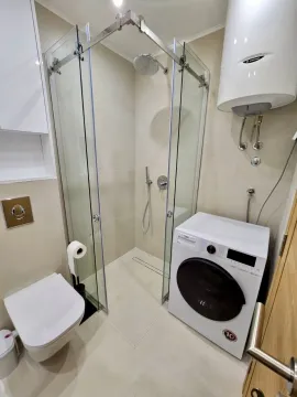 Kupatilo opremljeno tuš kabinom, WC šoljom i veš mašinom. - image 11