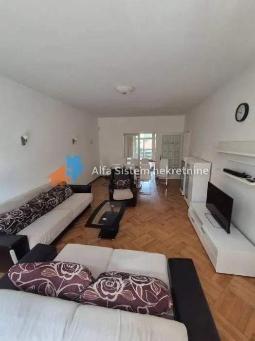 Spacious living room with a seating set and a dining area in the background.