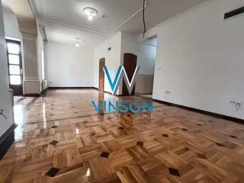 Empty spacious room with parquet flooring and wooden doors. - image 13