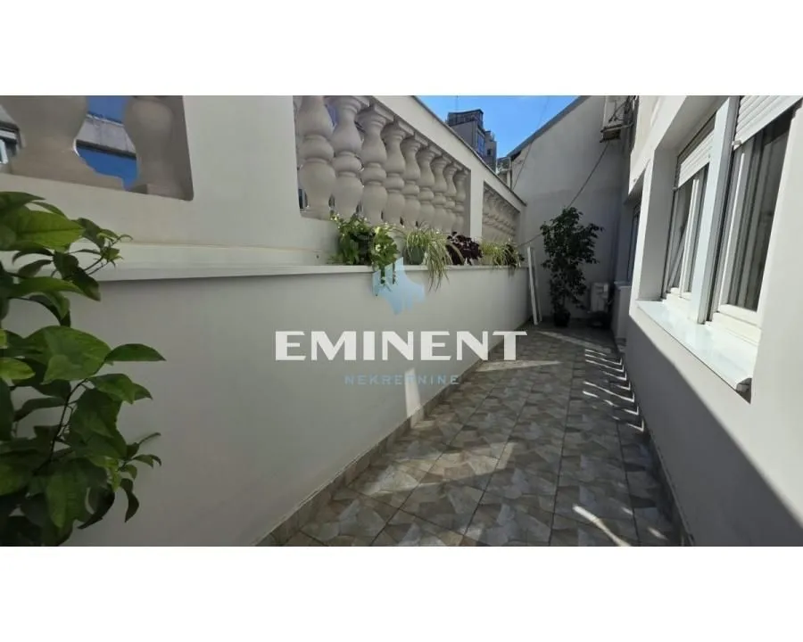 Tiled terrace with a balustrade and decorative plants.