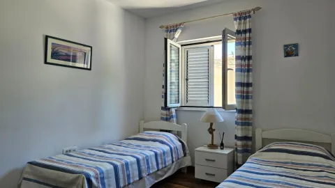 Spavaća soba sa dva kreveta za jednu osobu i prozorom. - image 18