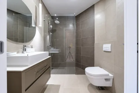 Modern bathroom equipped with a walk-in shower and washbasin. - image 15