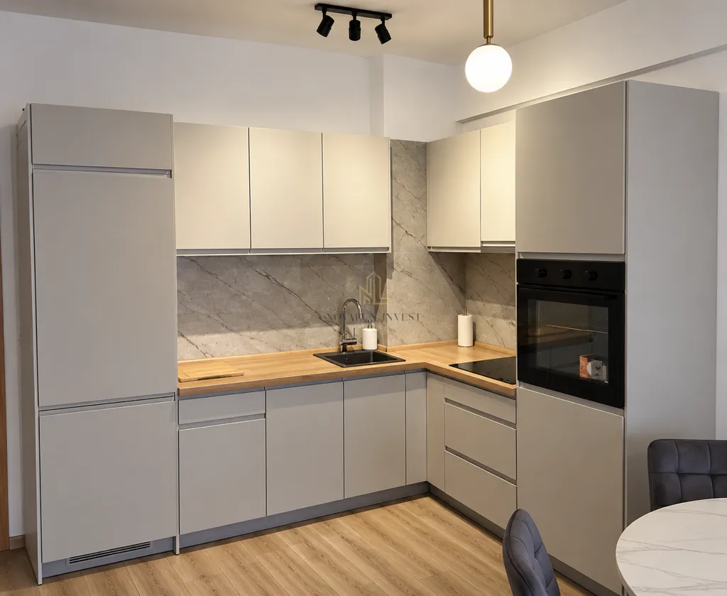 Modern kitchen with built-in appliances and wooden countertop.