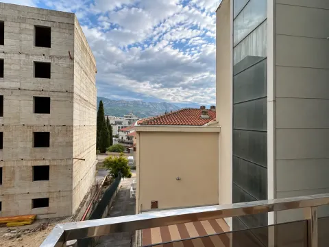 Pogled sa terase na okolne zgrade i planine u daljini. - image 7