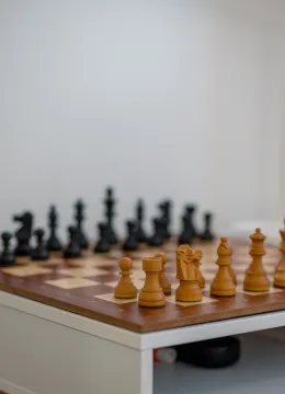 Drvena šahovska tabla sa figurama na bijelom stolu. - image 10