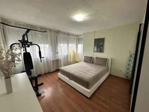 Spavaća soba sa bračnim krevetom i kućnom spravom za vežbanje. - image 3