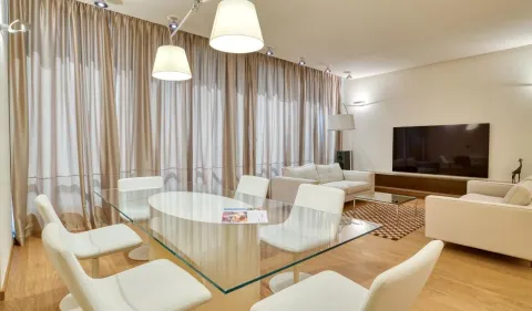 Spacious living room with a dining area, seating set, and large windows with curtains. - image 2