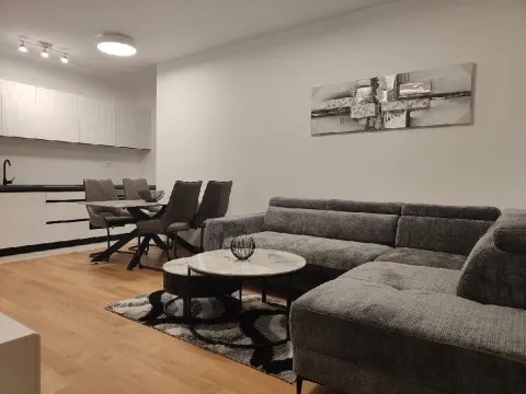 Svijetao dnevni boravak sa sivom ugaonom garniturom, trpezarijom i modernom kuhinjom. - image 2