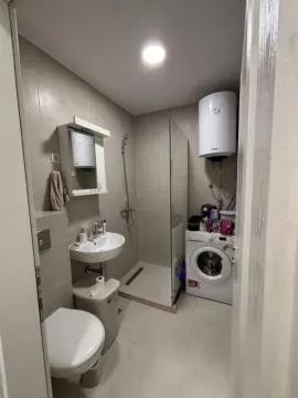 Manje kupatilo sa tuš kabinom, umivaonikom, WC šoljom i mašinom za veš. - image 3