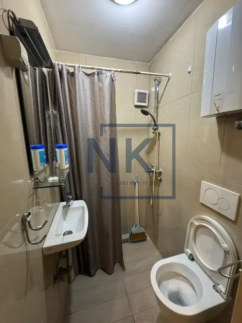 Smaller bathroom with a shower enclosure, washbasin, and toilet.