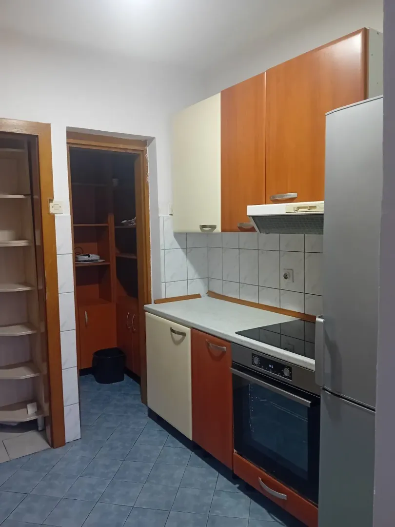 Jednostavna kuhinja sa drvenim elementima i ugradnom tehnikom.