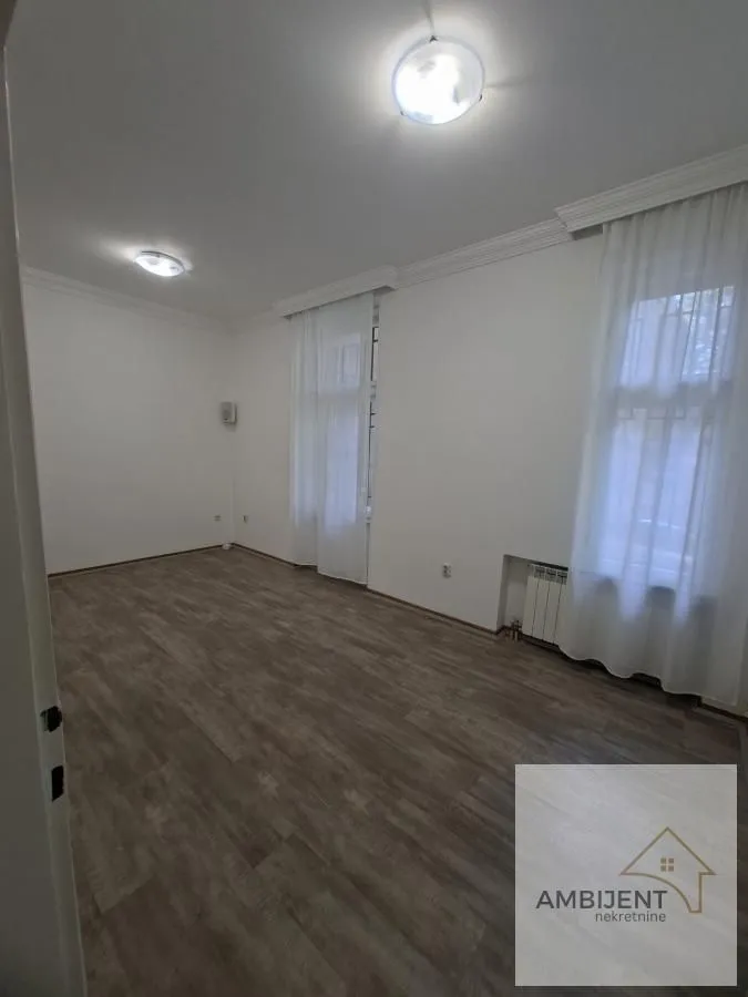 Empty room with laminate flooring and white walls.