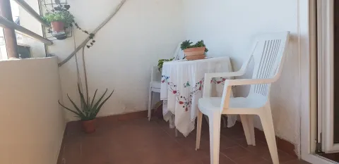 Mali balkon sa plastičnim stolom, stolicama i saksijama sa cvijećem. - image 15