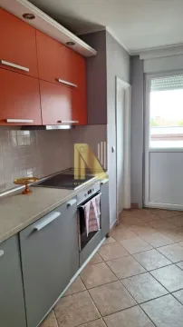 Smaller kitchen with orange and grey cabinets and tiled flooring. - image 3