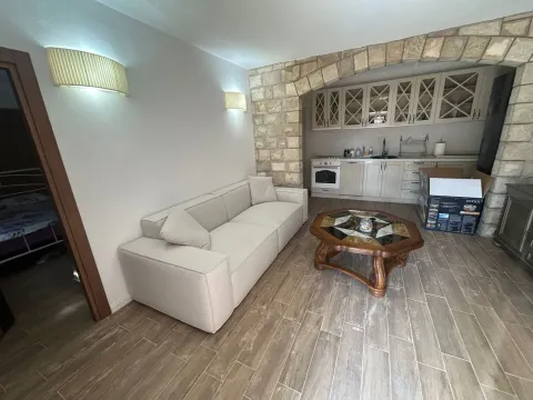 Dnevni boravak sa garniturom i pogledom na kuhinju sa kamenim lukom. - image 4