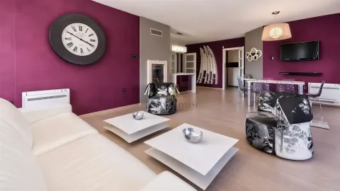 Spacious living room with seating area, dining space, and modern purple wall accents. - image 5