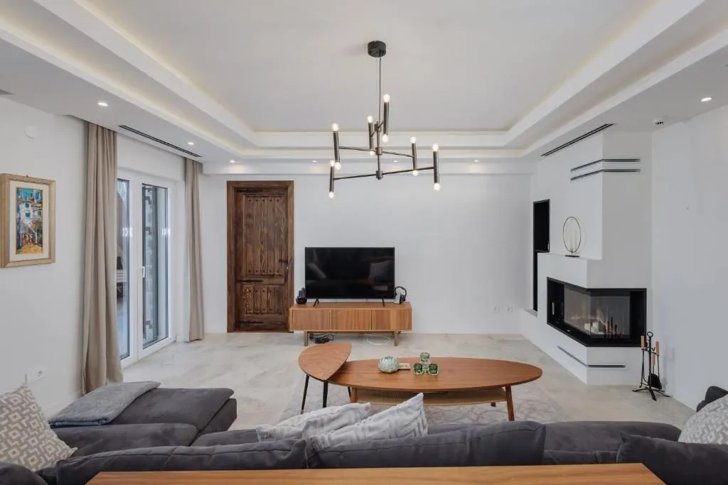 Modern and bright living room with a sofa, fireplace, and wooden coffee table.