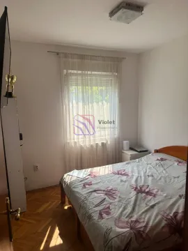 Spavaća soba sa krevetom, prozorom i parketom na podu. - image 6