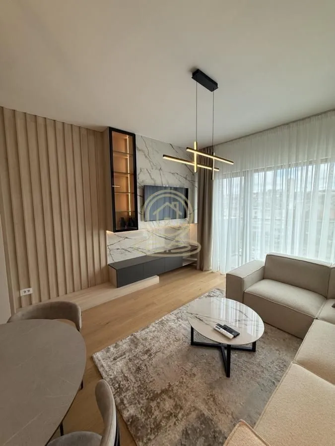 Modern living room with a sofa, TV, and dining table.