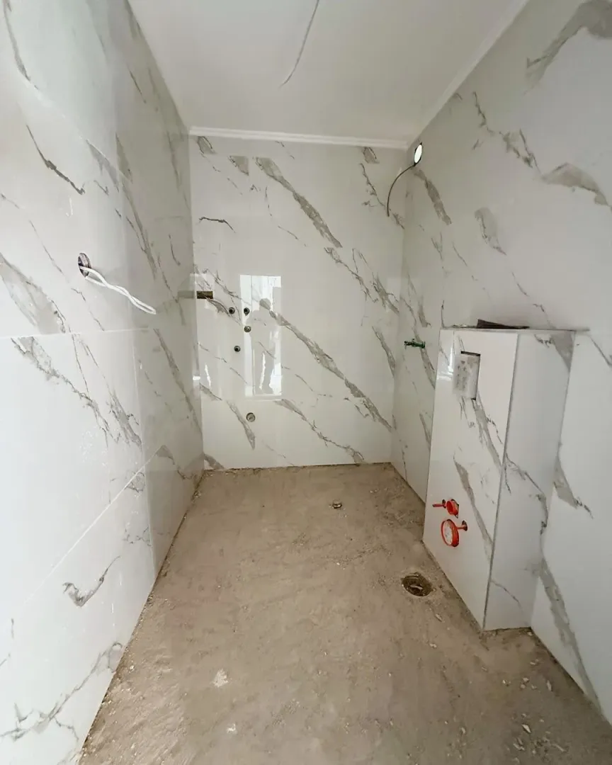Bathroom under renovation with marble tiles installed.