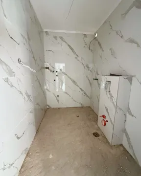 Bathroom under renovation with marble tiles installed. - image 5