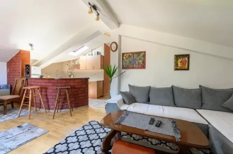 Spacious living room with a sofa and a bar leading to the kitchen. - image 6
