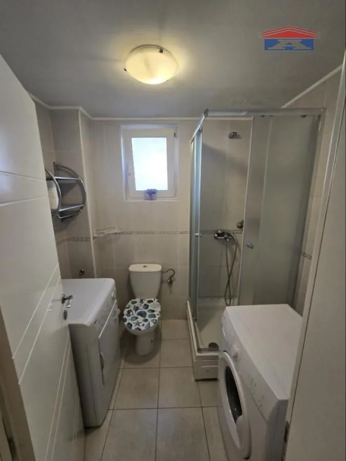 Kompaktno kupatilo sa tuš kabinom, WC šoljom i veš mašinom.