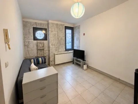 Small living room with a corner sofa, dresser, and television. - image 2